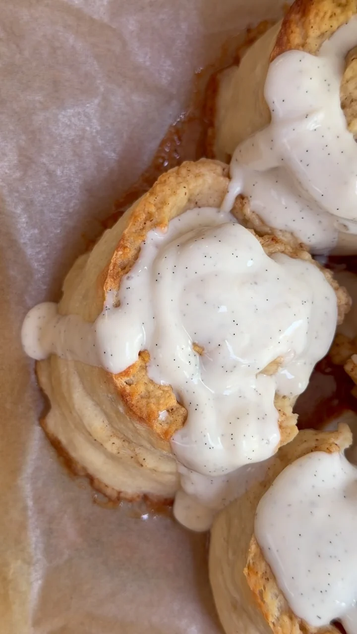 Cinnamon rolls with yogurt glaze on baking paper